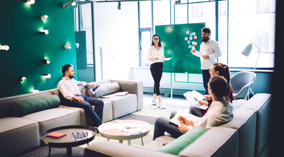 Coworkers having conversation in hall of workplace