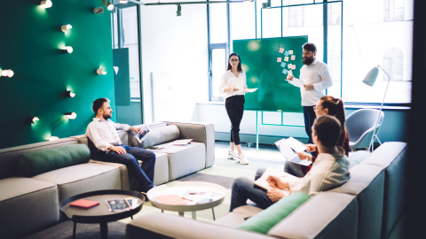 Coworkers having conversation in hall of workplace